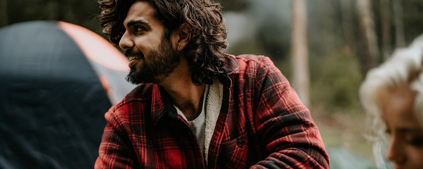 Man camping with friends, wearing a red Hard Yakka Sherpa Jacket