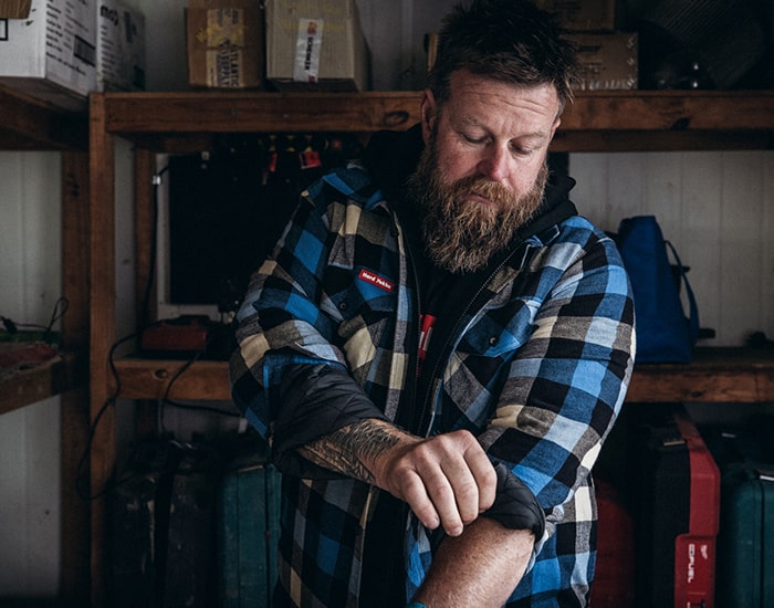 Man rolling up the sleeves of a Hard Yakka Quilted Shacket