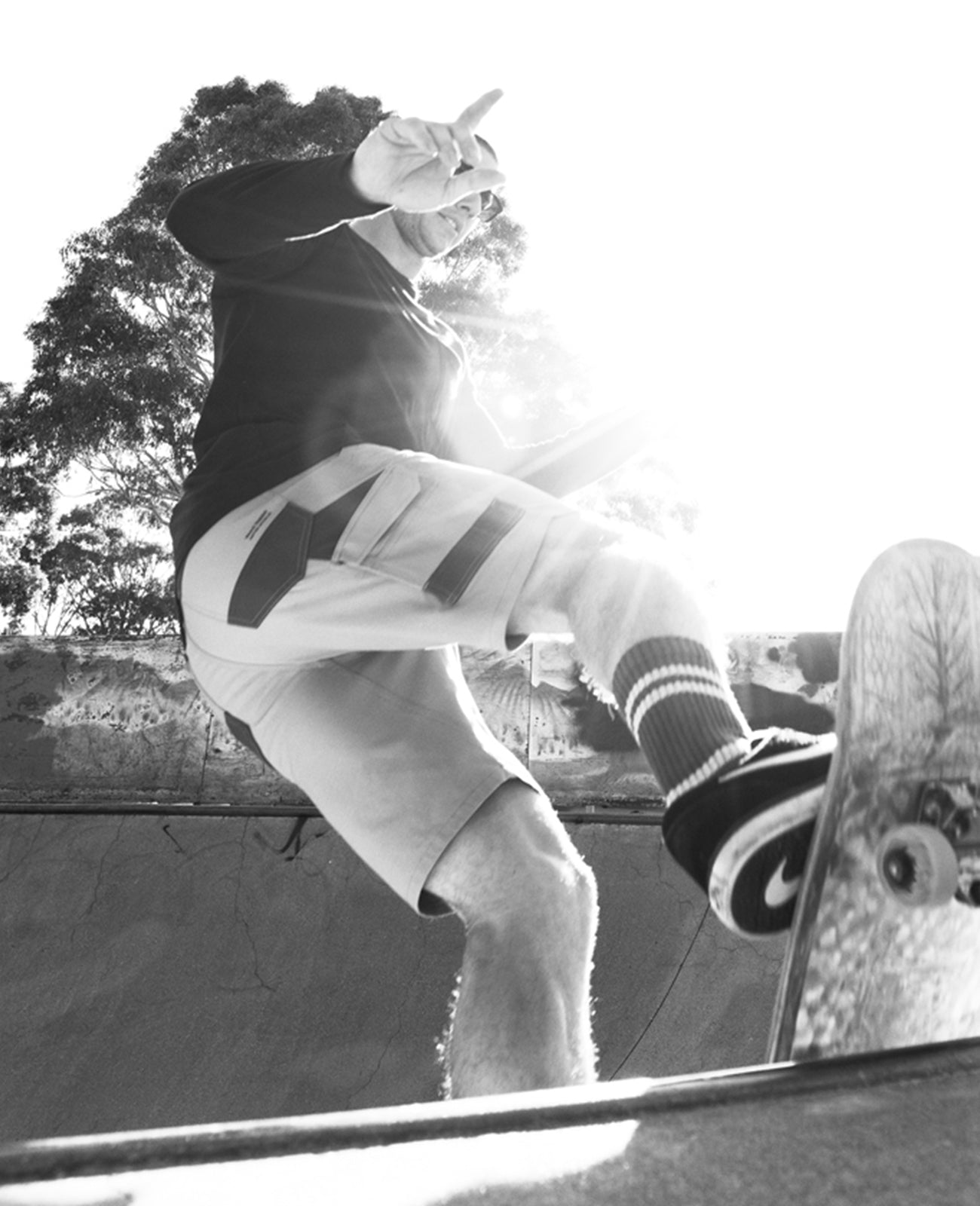 Black and white image of a man skateboarding, wearing a Hard Yakka t-shirt and shorts