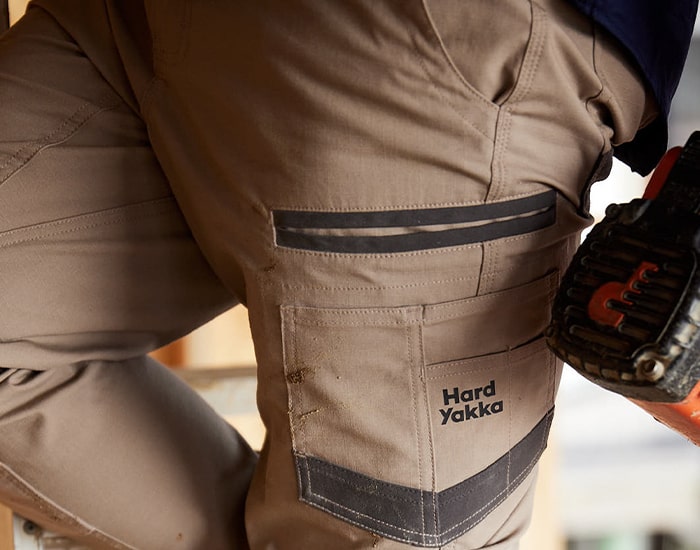 Close-up image of a person wearing a pair of Desert Hard Yakka Men's Raptor Active Cuffed Work Trousers