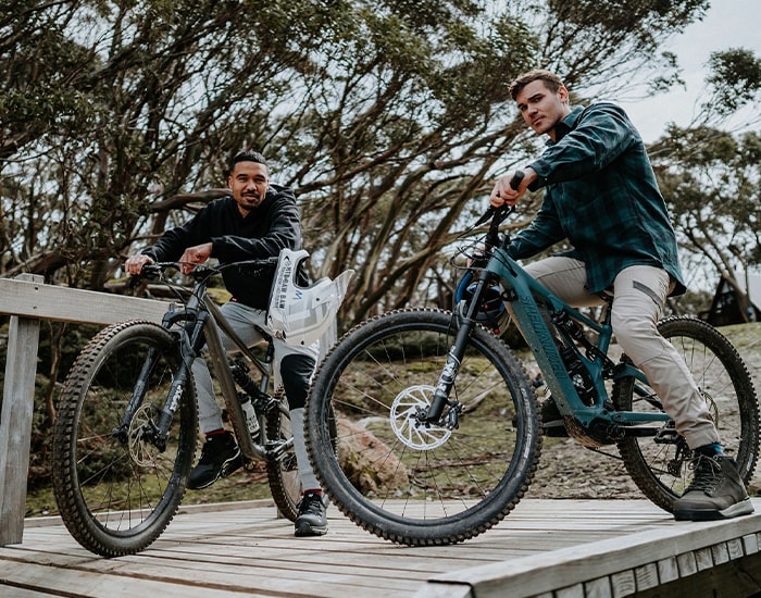 Two men on mountain bikes wearing Hard Yakka workwear